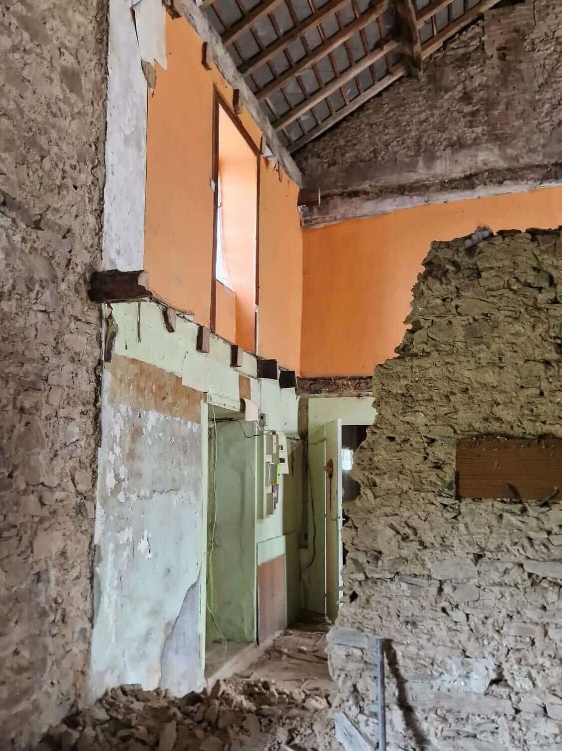 Vue intérieure montrant le mur séparant la maison de la grange, partiellement démoli lors de l’état des lieux.