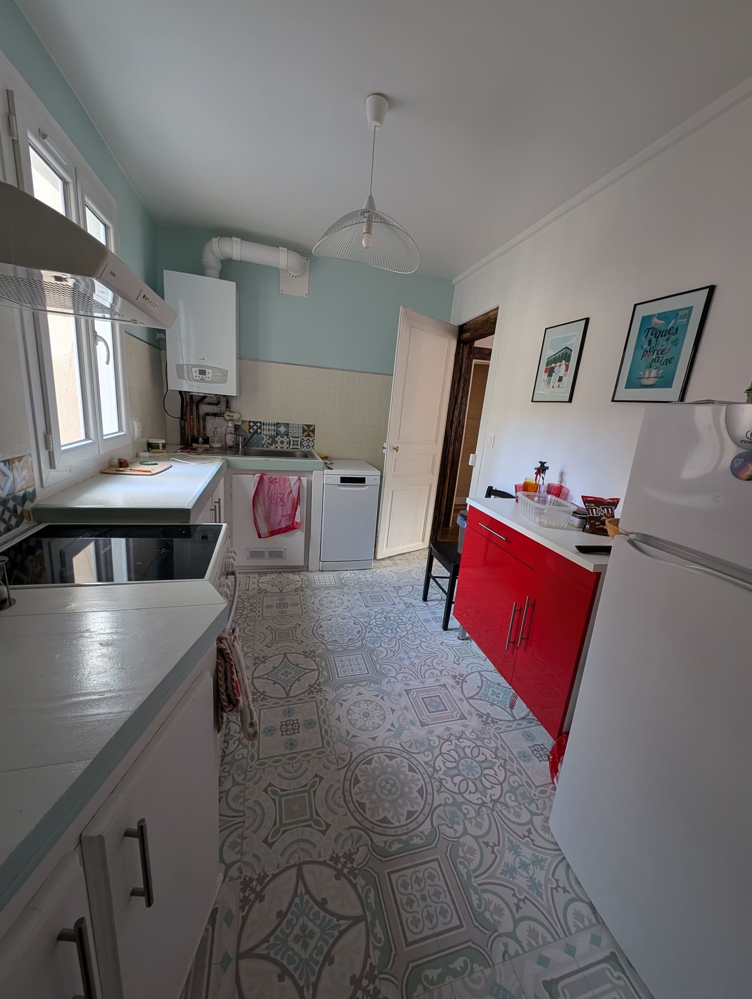 Vue de la cuisine existante avant travaux, avec implantation en longueur, équipements et rangements disparates.