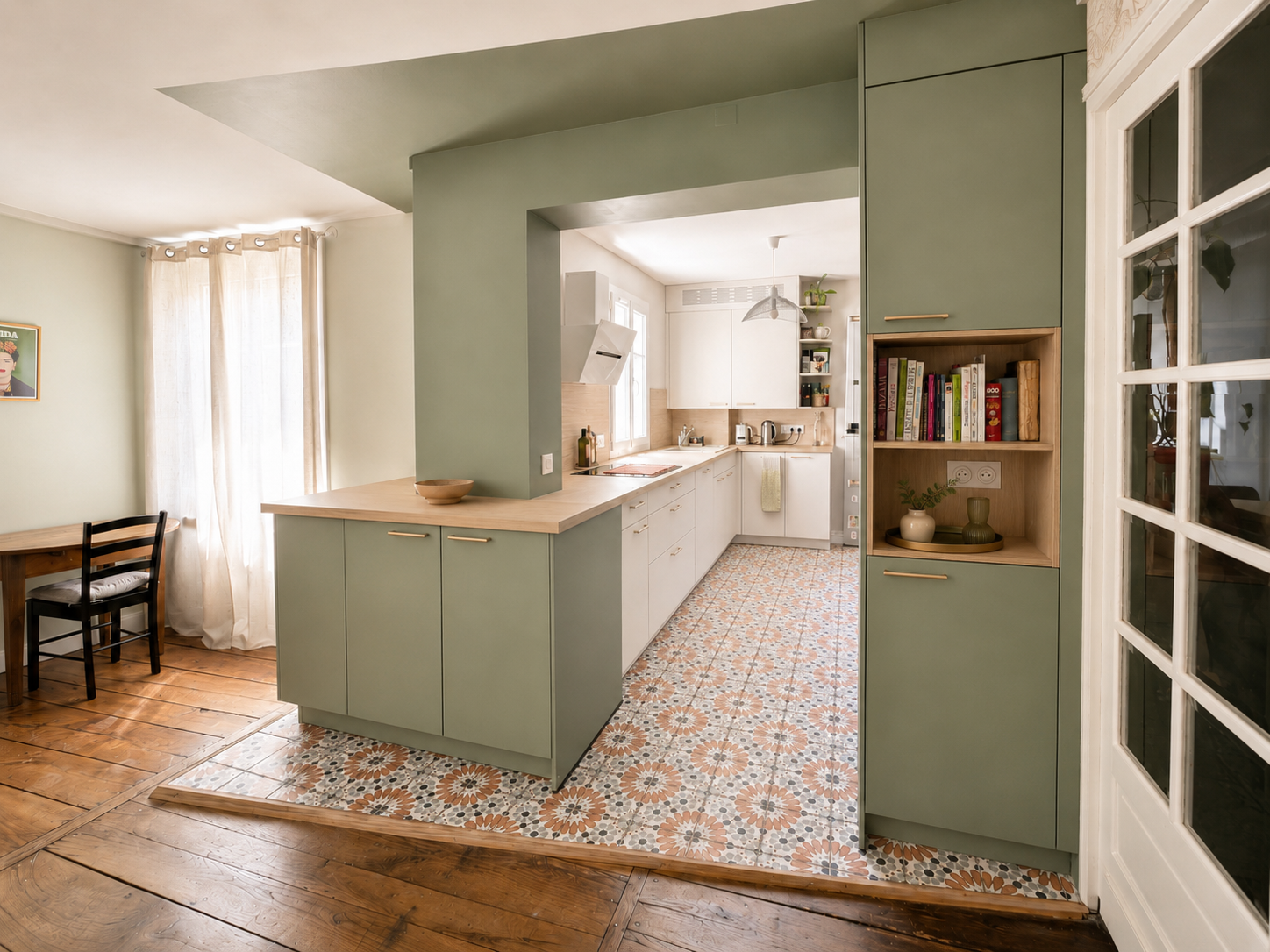 Cuisine rénovée ouverte sur le séjour avec mobilier vert sauge, façades blanches et carrelage à motifs